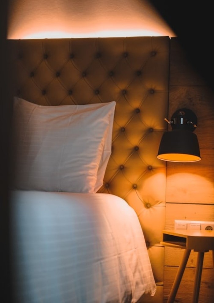 cama con luz apagada y lampara encendida