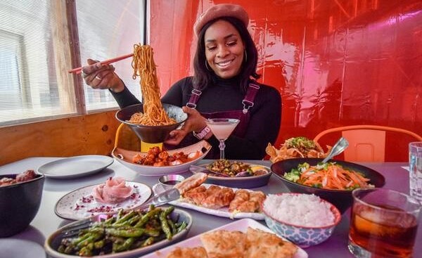 mujer en la mesa degustando comida oriental