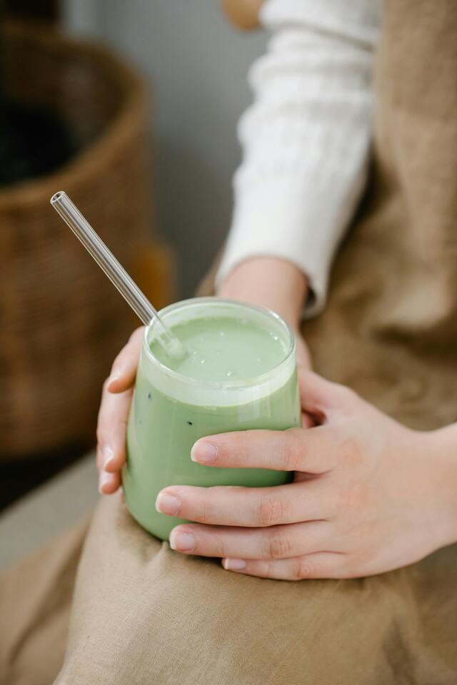 vaso con jugo sobre una rodilla