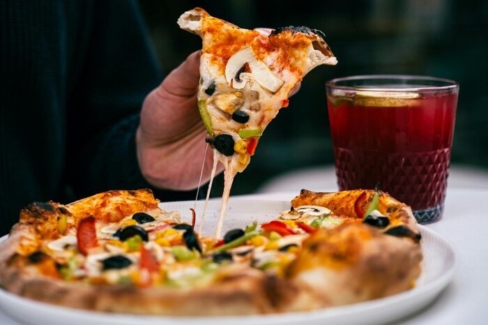 plato con pizza y un vaso con jugo