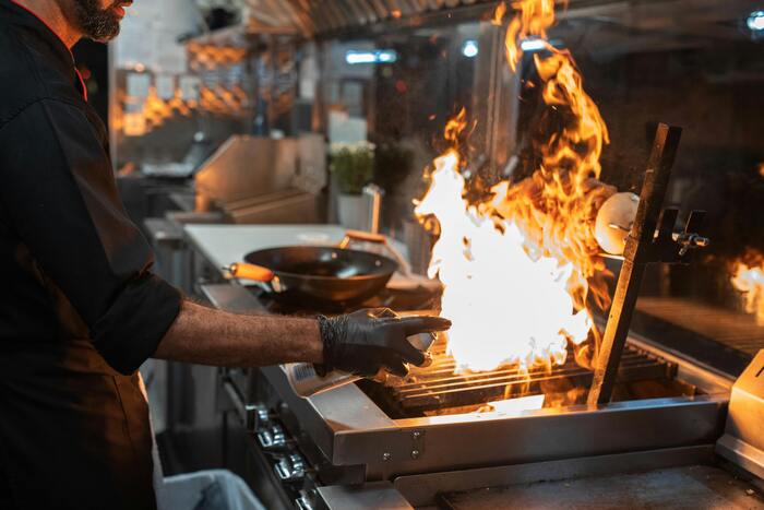 cocinero con una sarten en llamas